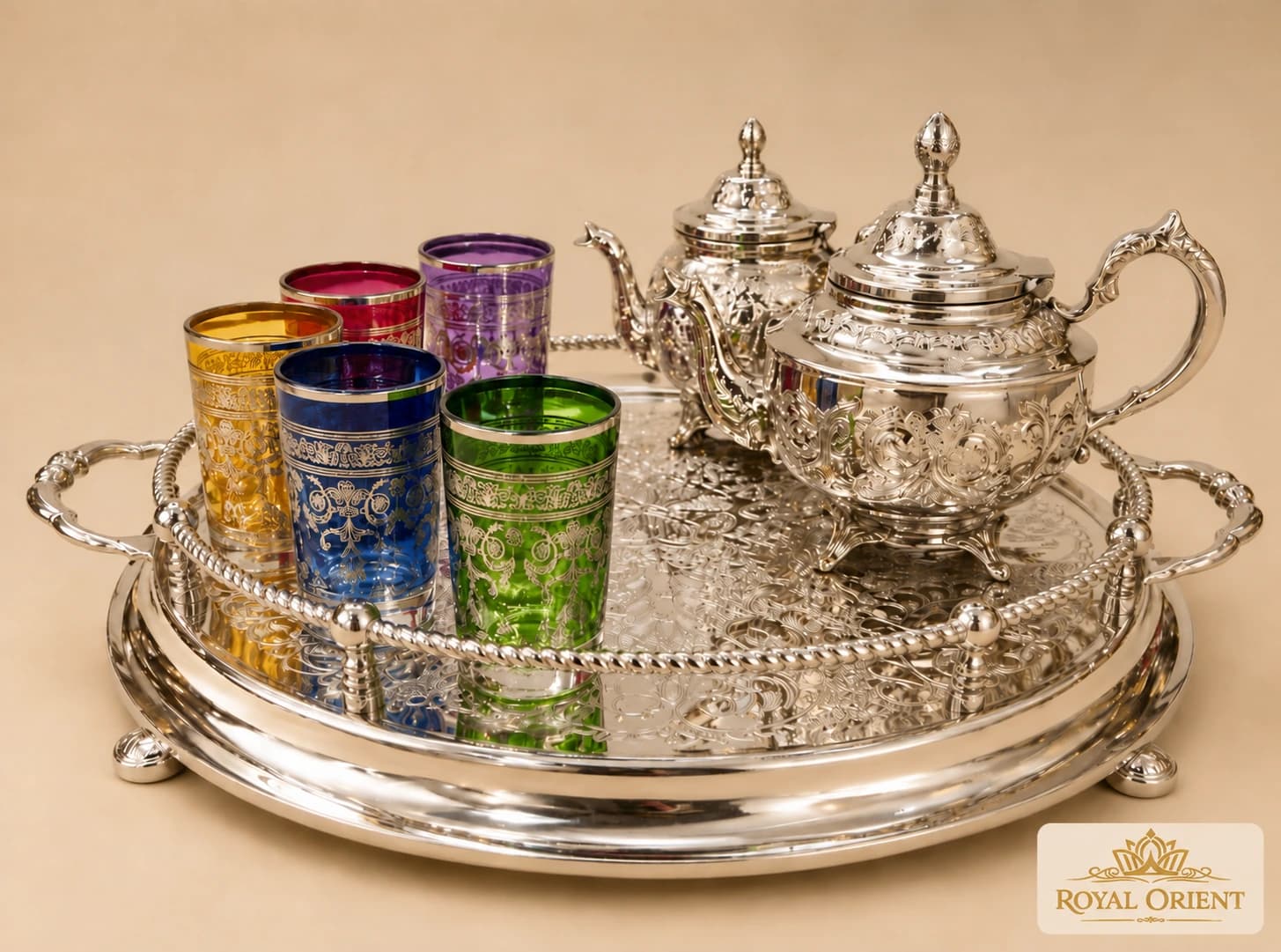 Silver Moroccan teapots with coloured tea glasses on an ornate tray